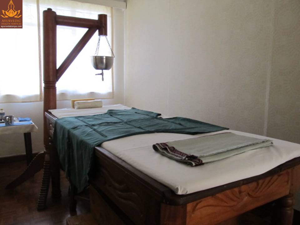 Shirodhara therapy — warm oil poured steadily on the forehead